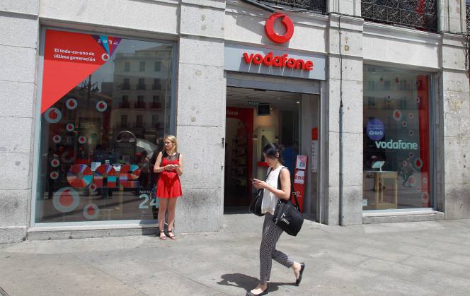 Usuaria de móvil frente a una tienda Vodafone