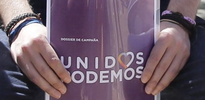 El líder de Podemos, Pablo Iglesias, sostiene el dossier de campaña con el logo de Unidos Podemos.