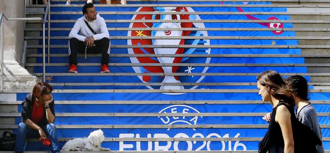 Dos jóvenes pasan ante las gradas de uno de los estadios que acogerán la Eurocopa.