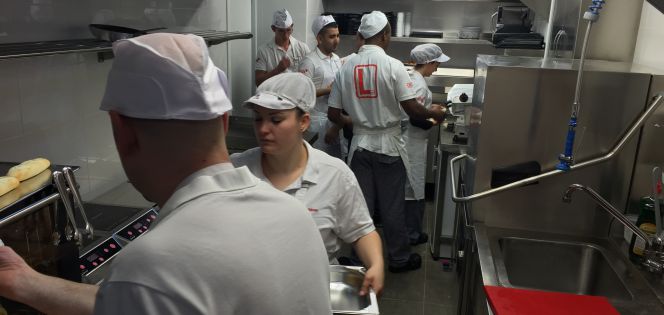 Un grupo de alumnos del bar-escuela de Lizarran en Madrid, en el ajetreo diario de la cocina.