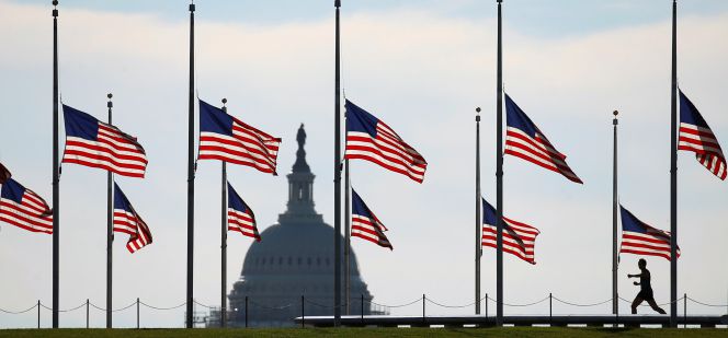 Varias banderas estadounidenses ondean a media asta en Washington, junto al Capitolio.