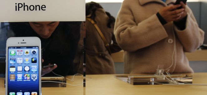 Un joven probando un modelo de iPhone en una tienda de Apple en Pekín.