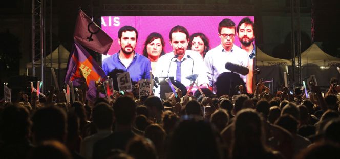 Simpatizantes de Unidos Podemos escuchan las declaraciones de su líder Pablo Iglesias.