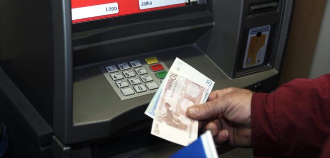 Un hombre retira euros de un cajero automático.
