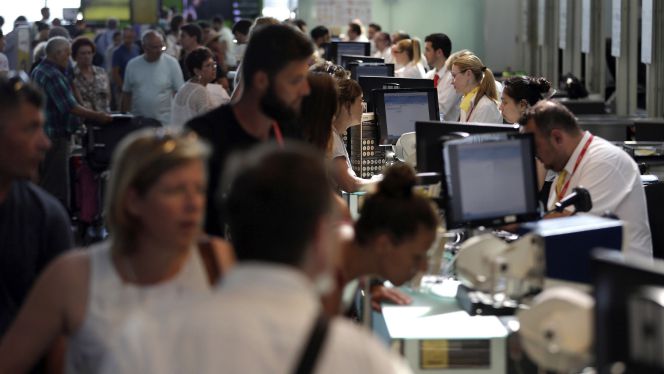 Personal de facturación de Vueling atiende a los viajeros en el Aeropuerto de El Prat.