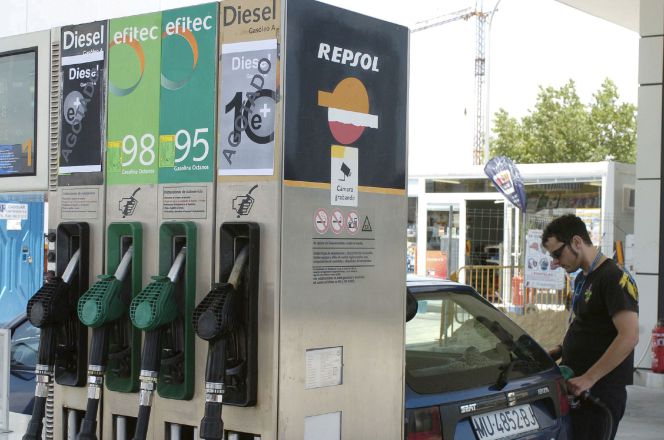 Un joven pone gasolina a su coche en un surtidor. EFEArchivo