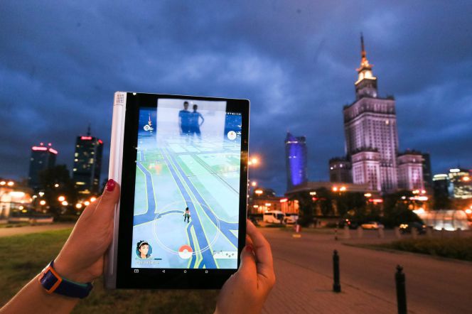 Una joven juega con la aplicación Pokemon Go cerca al Palacio de la Ciencia y la Cultura de Varsovia (Polonia)