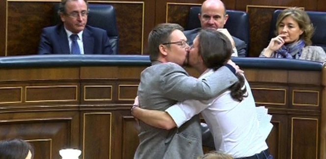 El líder de Podemos, Pablo Iglesias, y el de En Comú Podem, Xavier Doménech, se besan en el debate de investidura de la anterior legislatura.