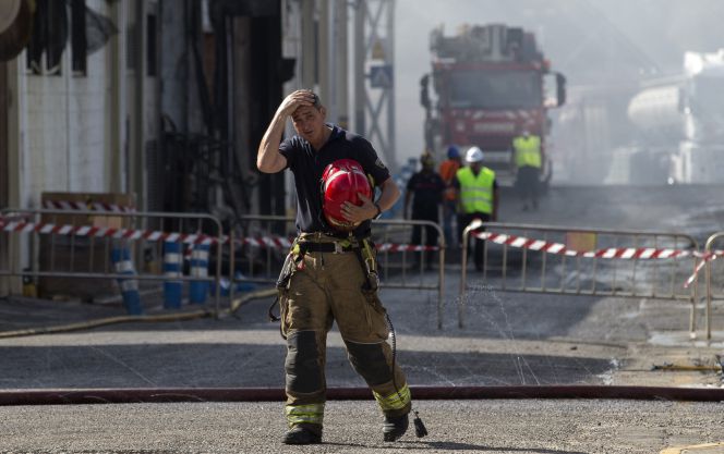 Un bombero sale de la zona afectada por el incendio declarado el sábado a mediodía en la fabrica de aceite y mayonesa del Grupo Ybarra en Dos Hermanas (Sevilla)