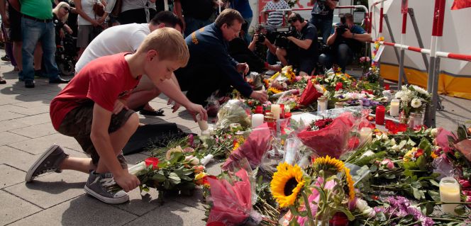 Ciudadanos ponen flores y velas en el exterior del centro comercial donde tuvo lugar el tiroteo.