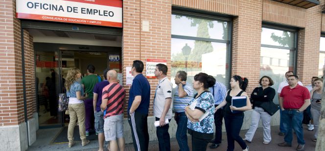 Un grupo de personas hace cola en una oficina de empleo en Alcalá de Henares.