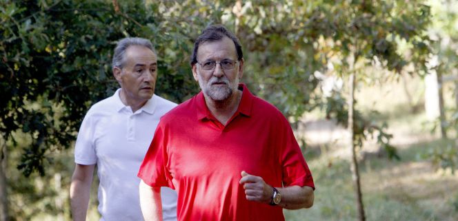 El presidente del Gobierno en funciones, Mariano Rajoy (d), acompañado por José Benito Suárez (i), marido de la presidenta del Congreso, Ana Pastor, en su recorrido por la ruta del río Umia, situada en el municipio de Ribadumia (Pontevedra), un largo paseo que acostumbra a realizar en sus días de descanso en la localidad gallega.