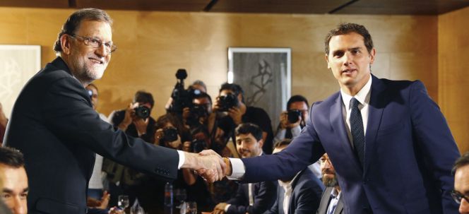 El jefe del Gobierno, Mariano Rajoy,iz., y el líder de Ciudadanos, Albert Rivera, se estrechan la mano durante la reunión de sus respectivas delegaciones en la que van a certificar el acuerdo de investidura.l