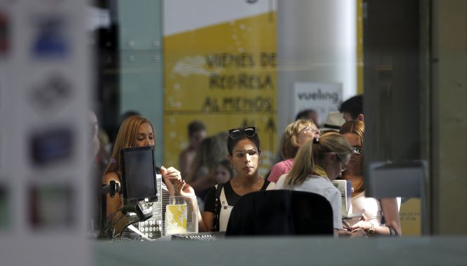 Pasajeros de Vueling en un mostrador de facturación.