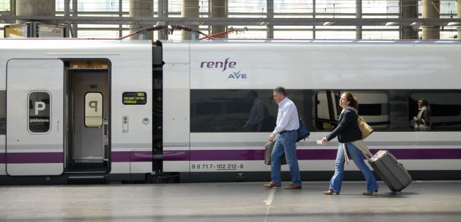 Viajeros caminan antes de subir a un AVE de Renfe.
