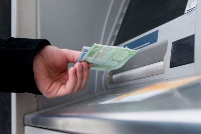 Un hombre saca euros de un cajero automático.