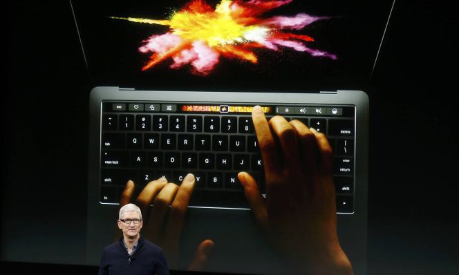 El presidente de Apple Tim Cook habla bajo la imagen del nuevo Mac Book Pro en la presentación ante los medios en Cupertino, California.