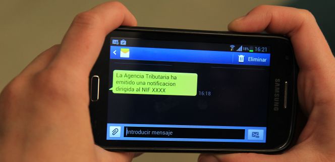 Un teléfono con el mensaje que la Agencia Tributaria remite a los contribuyentes que sean destinatarios de una notificación fiscal y se hayan adherido al programa de alertas.