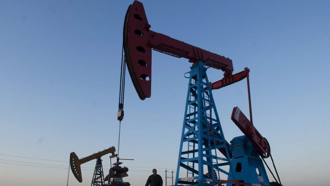Un trabajador bajo un pozo de petróleo.