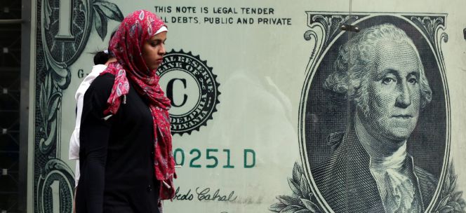 Una mujer camina delante de una oficina de cambio de divisas, en El Cair (Egipto).rn rn rn rn rn rn *** Local Caption *** rn .