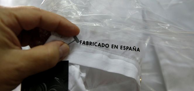 Una trabajadora coloca una etiqueta en una fábrica textil.