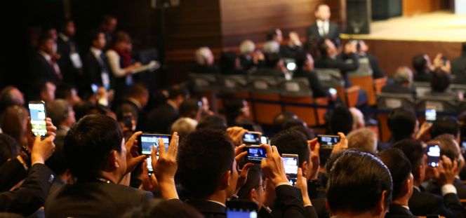 Asistentes a la cumbre de la APEC en Lima fotografían al presidente de China, Xi Jinping (fuera de imagen).