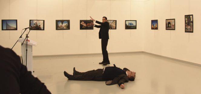 El supuesto atacante, identificado como Mevlüt Mert Altintas (atrás) permanece junto al cuerpo sin vida del embajador ruso en Turquía, Andréi Karlov.
