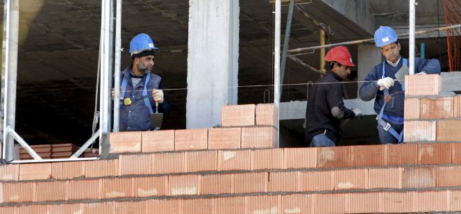 Tres obreros trabajan en la construcción de una vivienda.