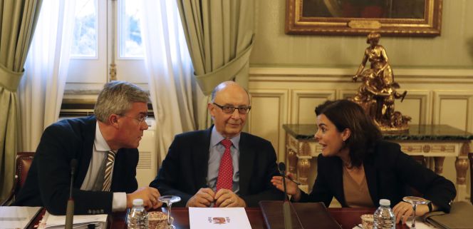 El ministro de Hacienda, Cristóbal Montoro, flanqueado por la vicepresidenta del Gobierno, Soraya Sáenz de Santamaría, y el secretario de Estado de Hacienda, José Enrique Fernández de Moya. efe