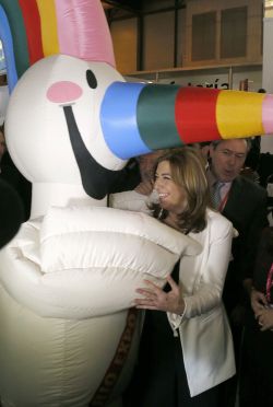 La presidenta de Andalucía, Susana Díaz, saluda a la mascota que conmemora el próximo 25 aniversario de la EXPO 92,