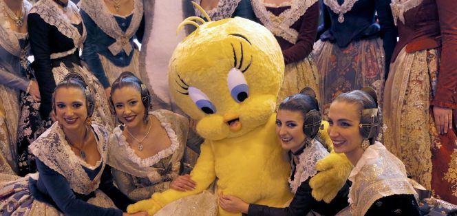 Varias mujeres vestidas de falleras posan con un Piolín, ayer en Fitur.
