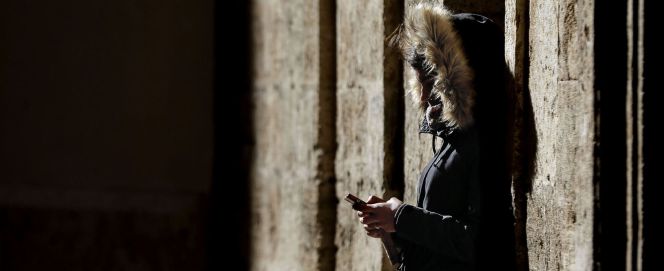 Una jóven consulta su teléfono móvil, este mediodía en Valencia.