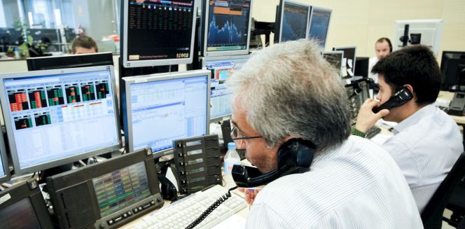 Los agentes de Ahorro Corporación, grupo de servicios financieros encargado de la subasta de bonos y letras del Tesoro Público.