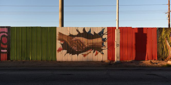 Vista de una pintada sobre la cerca fronteriza que divide al estado de Mexicali ( México) y Calexico (EEUU).