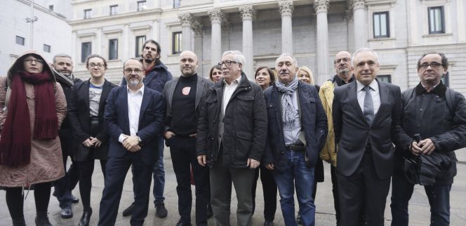 Los secretarios generales de CCOO y UGT, Ignacio Fernández Toxo, y Pepe Álvarez, posan ante el Congreso con diputados que apoyaron la renta mínima de 426 euros.