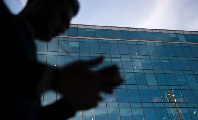 Un usuario maneja su teléfono móvil en una zona empresarial.