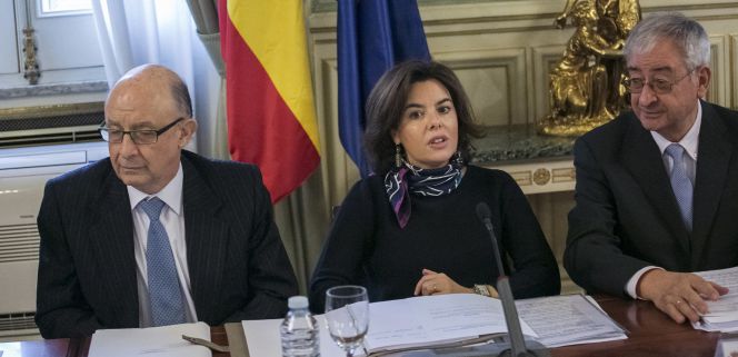 La vicepresidenta del Gobierno, Soraya Sáenz de Santamaría, junto al ministro de Hacienda y Función Pública, Cristóbal Montoro, y el presidente de la comisión de expertos, Manuel González Sánchez.