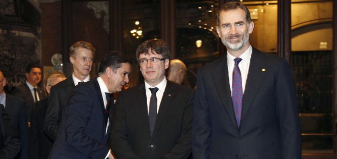 El rey Felipe VI junto al presidente de la Generalitat, Carles Puigdemont, a su llegada a la cena de bienvenida a los asistentes al Mobile World Congress (MWC), en el Palau de la Música.