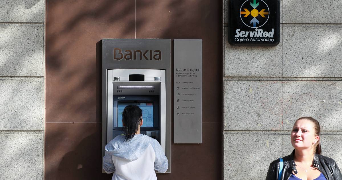 Una cliente opera en un cajero de Bankia.