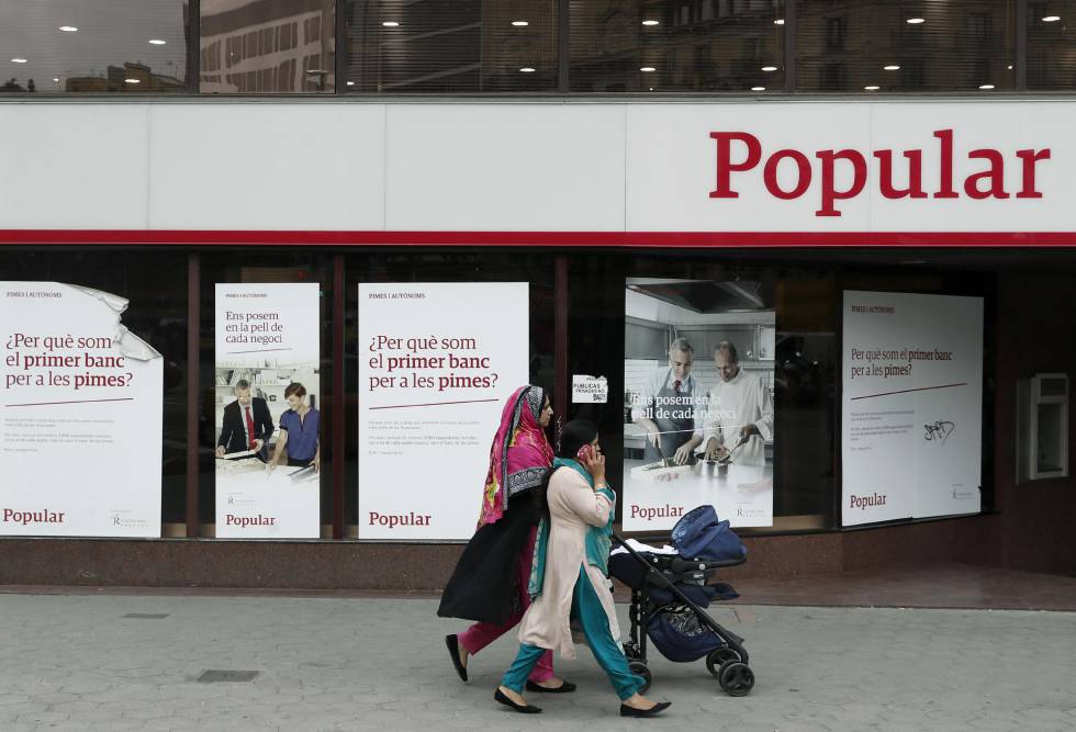 Unas mujeres pasan ante una oficina del Banco Popular en Barcelona. EFEArchivo