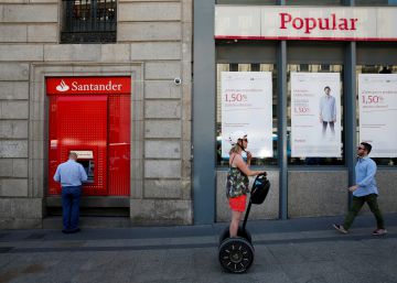 Un hombre saca dinero de un cajero automático de Santander, ahora dueño de Popular