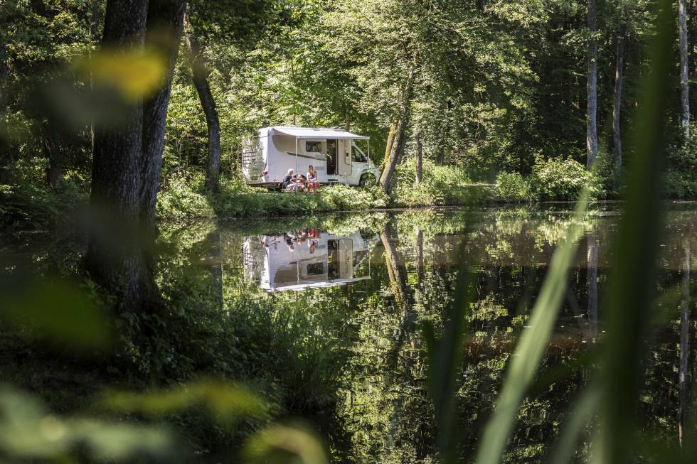 Autocaravana al lado de un lago en un parque natural.
