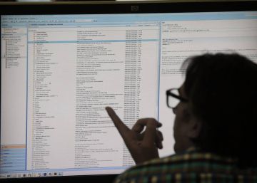 Un hombre consulta su correo electrónico en un ordenador en su puesto de trabajo.