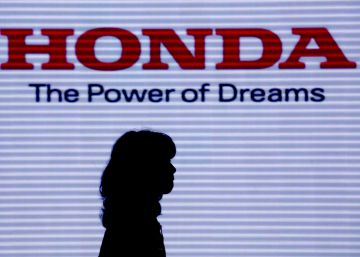 Una mujer pasa por delante del cartel de la firma japonesa Honda.