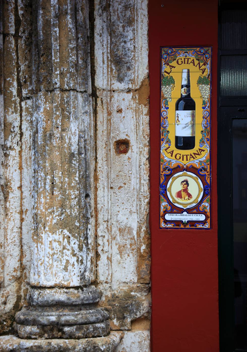 Detalle de un columna junto a una publicidad de un vino.