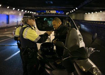 Un agente de la Guardia Urbana de Barcelona hace la prueba de alcoholemia a un motorista, en diciembre pasado.