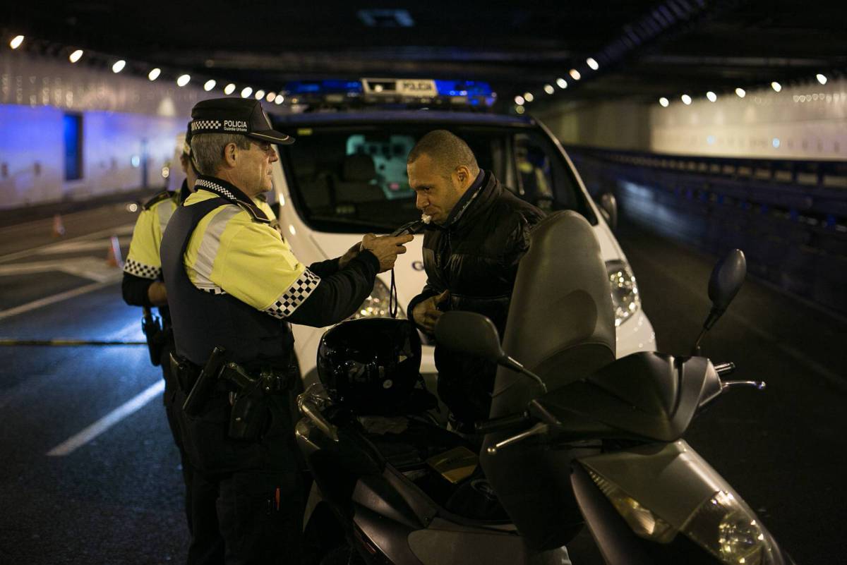 Un agente de la Guardia Urbana de Barcelona hace la prueba de alcoholemia a un motorista, en diciembre pasado.