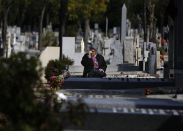 Una mujer llora frente a la lápida de un familiar en el cementerio madrileño de La Almudena.