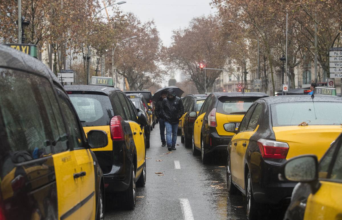 Taxis estacionados en la calzada central de la Gran Via de Barcelona por la huelga contra los VTC.