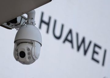Cámara de vigilancia junto a un letrero de Huawei, en Pekín.